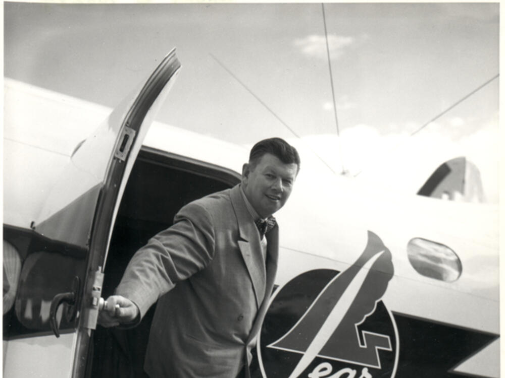 A man stepping out of the door of a small aircraft that says "lear" on its side.