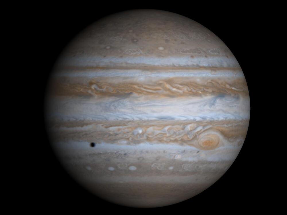 A disc with stripes of different colored cloud bands. In the bottom left is a dark circle.