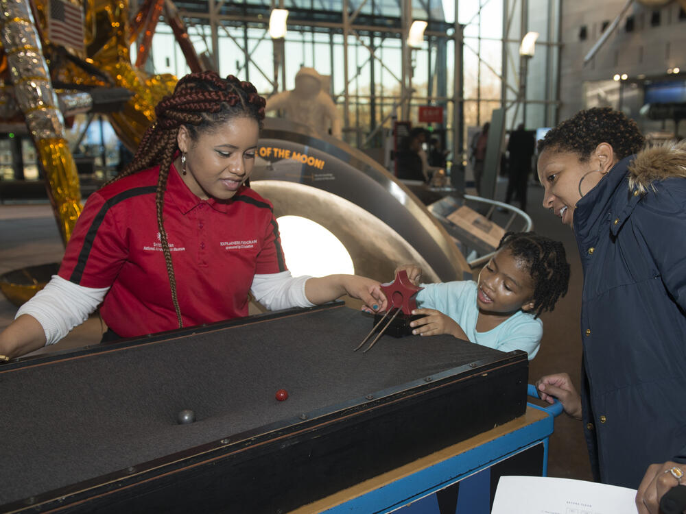 Explainer interacts with visitor at museum