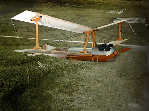 Photo illustration of a small, unpiloted biplane with a metal and brown wood chassis flying over a countryside with a tiny white biplane below.