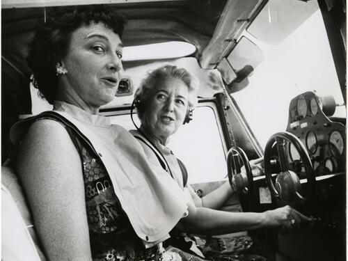 Two women, pilot Edna Whyte and her student, Martha Wright, sit in the cockpit of an aircraft during an air race.